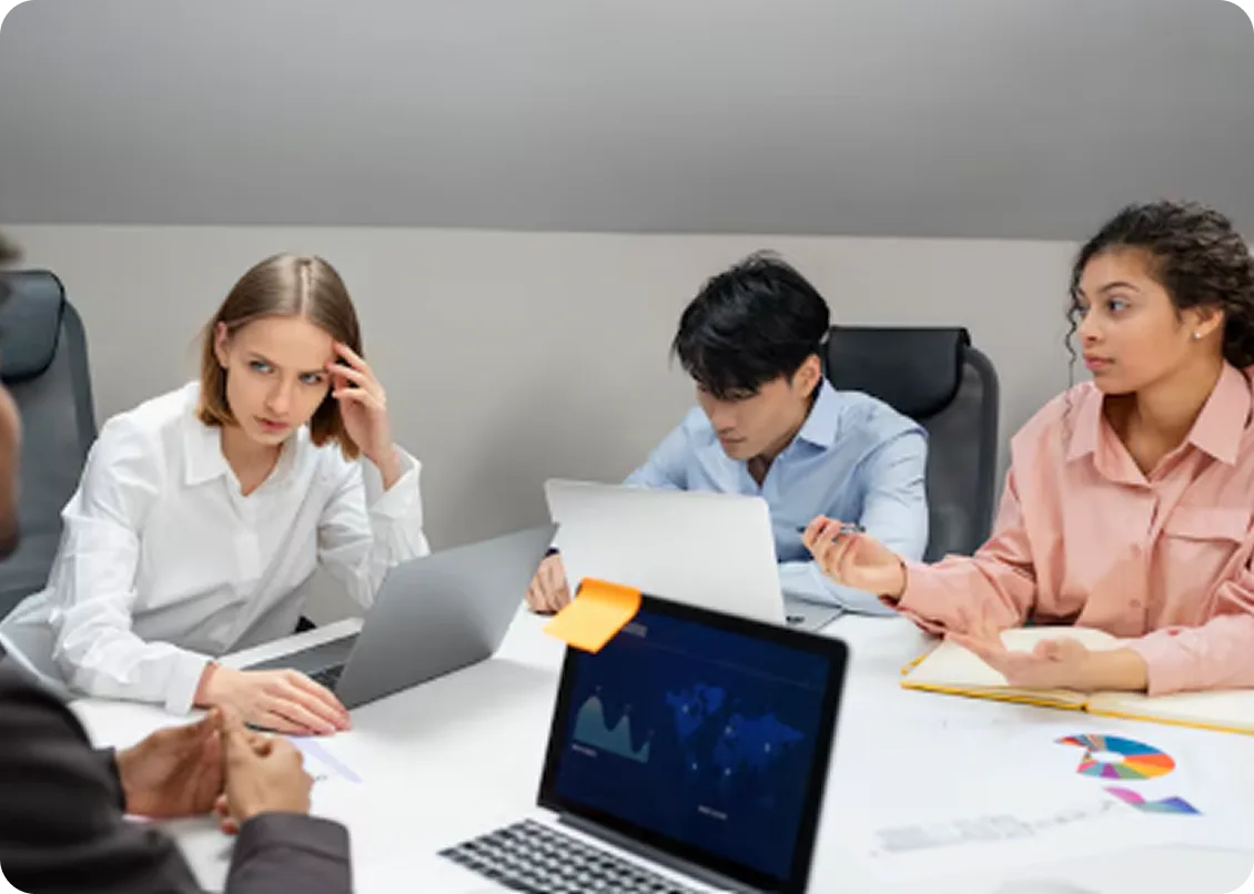 Clinical and operations team collaborating with laptops in an office